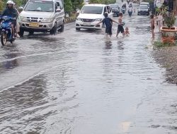 Genangan Air Hujan di Jalan Trans Sulawesi Palopo Dijadikan “Kolam Renang” oleh Anak-anak